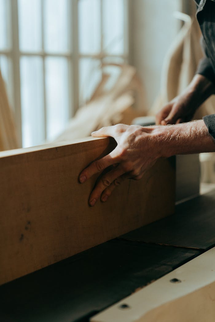 Mastering the First Impression: Your intriguing post title goes here Close-up of a craftsman's hands working with wood in a workshop setting.